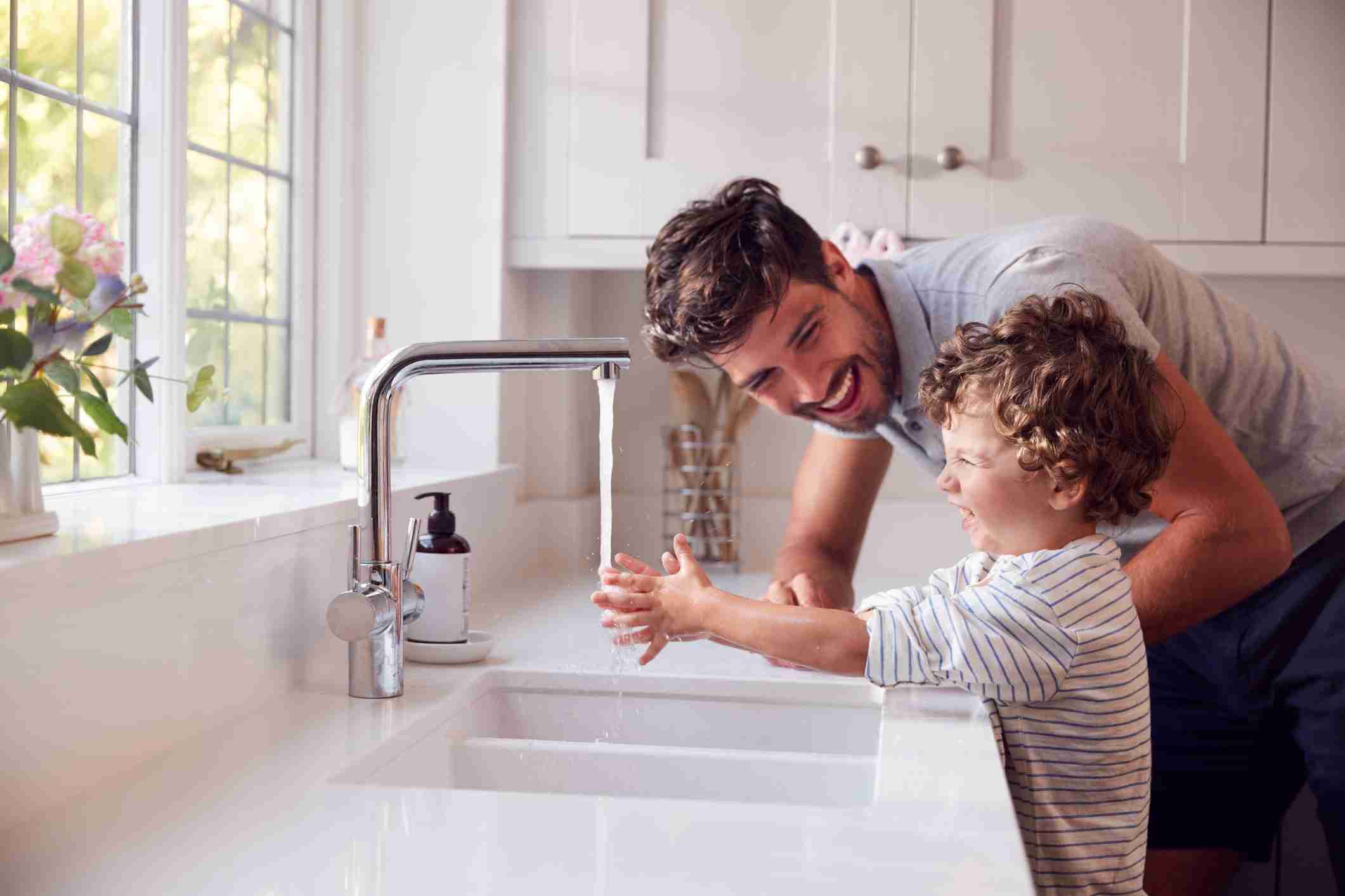 Father Helping Son To Wash Hands With Soap At Home-min sml