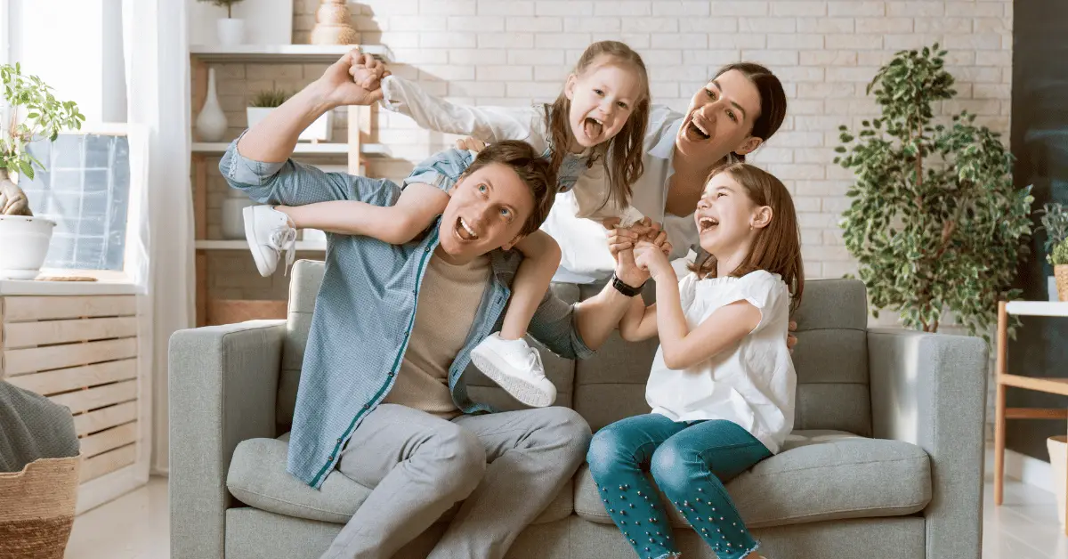 A group of smiling individuals relaxing in their home filled with laughter and good company